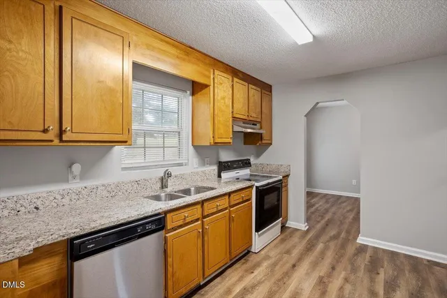a kitchen with stainless steel appliances granite countertop a sink stove and cabinets