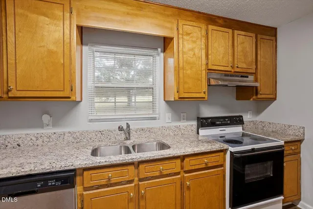 a kitchen with stainless steel appliances granite countertop white cabinets and a granite counter tops