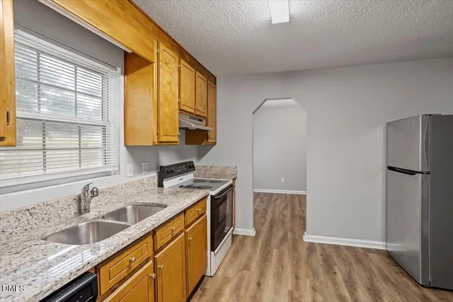 a kitchen with granite countertop a sink a counter space and cabinets