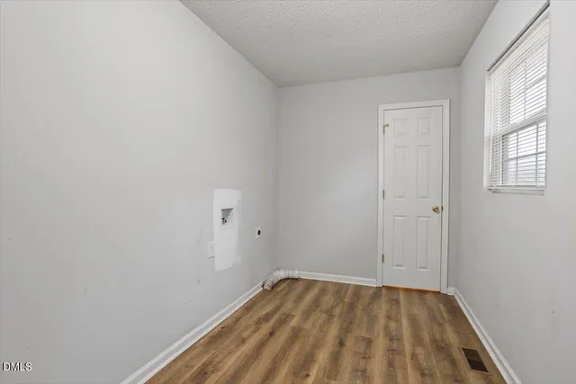 a view of a room that has wooden floor and fan