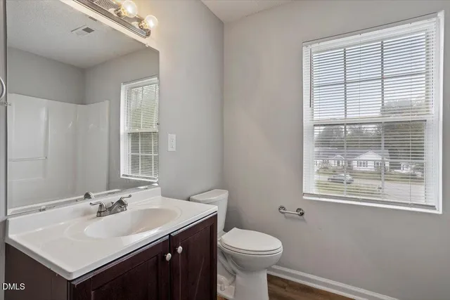 a bathroom with a sink toilet and a window