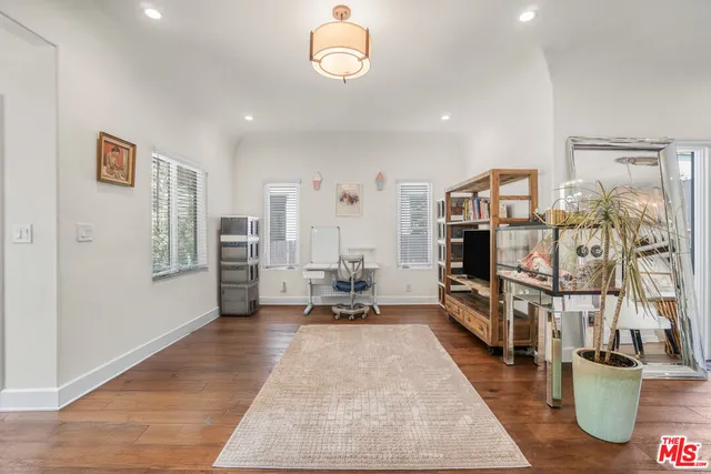 a living room with furniture a flat screen tv and a table