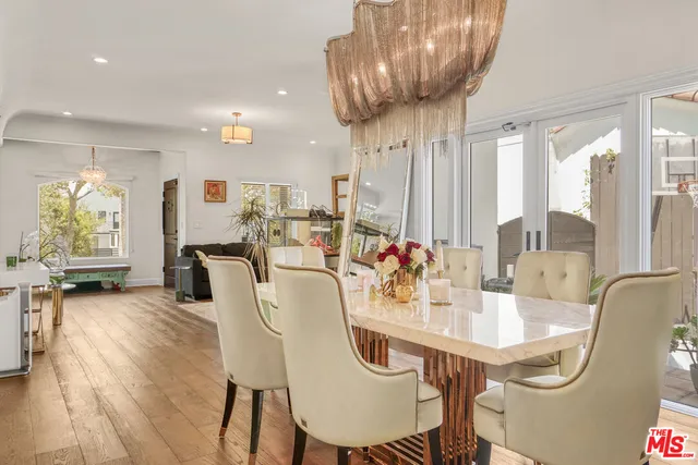 a dining room with furniture a chandelier and wooden floor