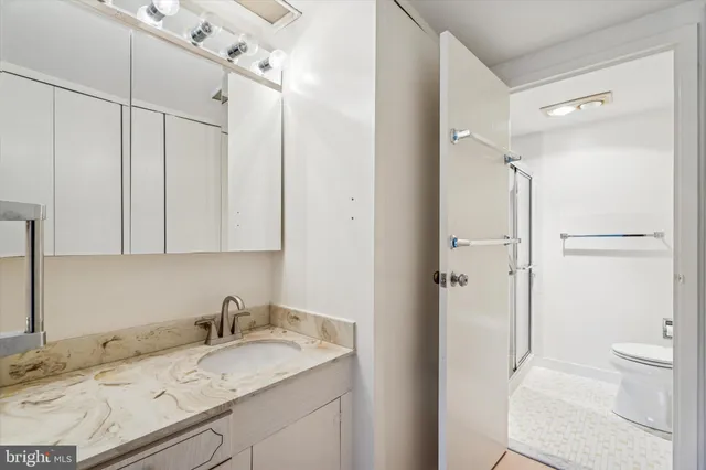 a bathroom with a granite countertop sink toilet and shower