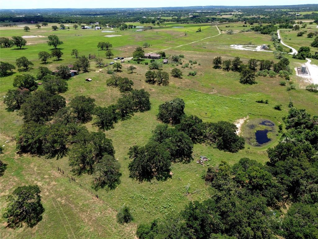 2186 Gilliland Road Springtown, TX 76082 - Photo 17 of 25 Expansive acreage featuring abundant mature trees, open grassy areas, and a visible pond