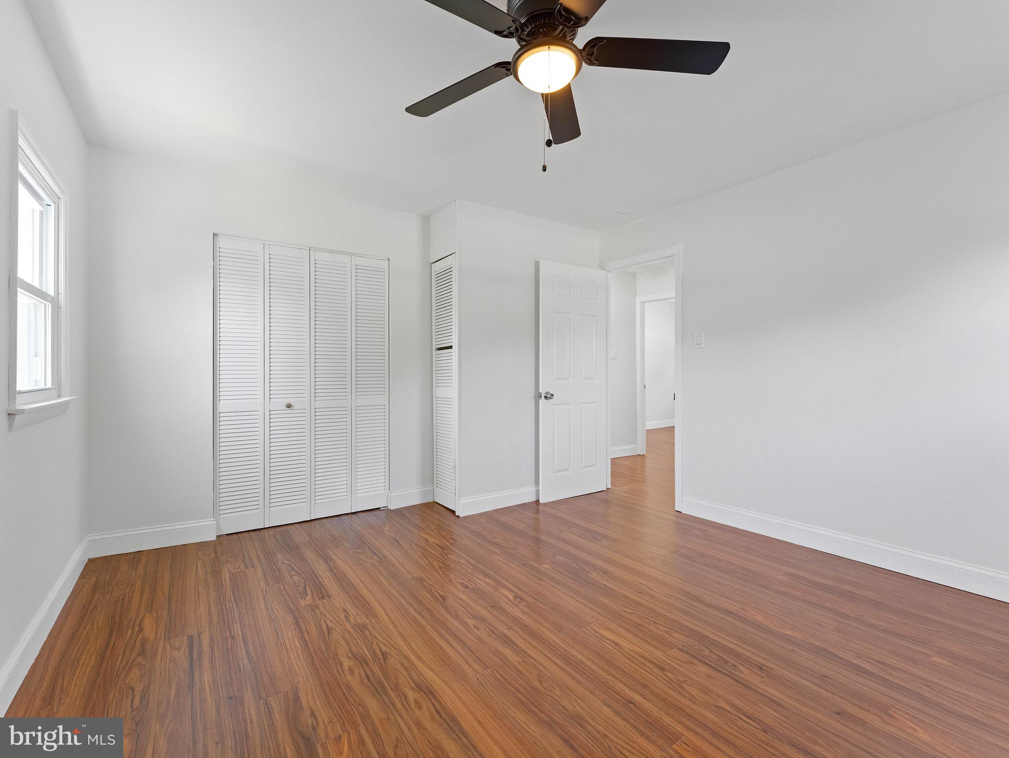 157 West Browning Road Bellmawr, NJ 08031 - Photo 17 of 41 an empty room with wooden floor ceiling fan and windows