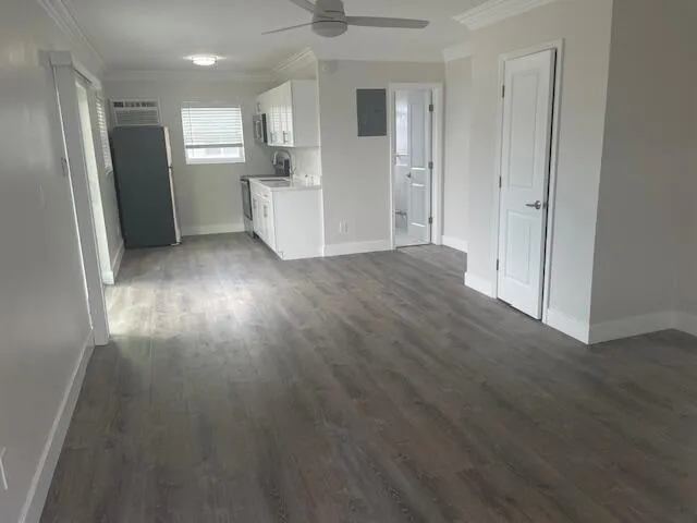 a view of a kitchen with refrigerator and wooden floor