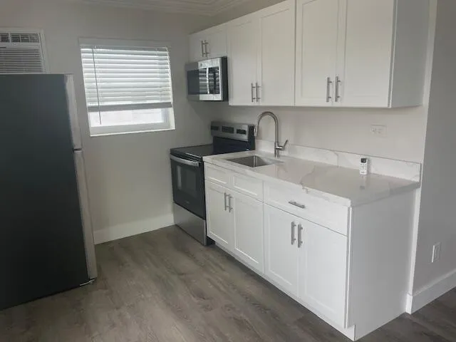 a room with a sink cabinets and a window