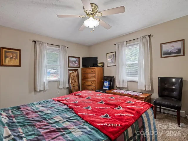 a bedroom with a bed dresser and a flat screen tv