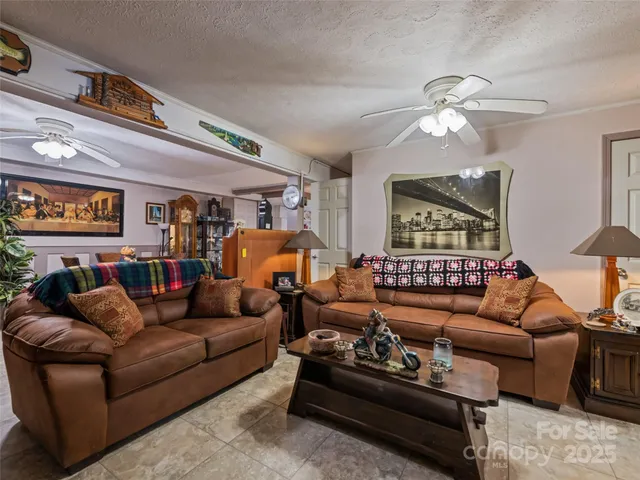 a living room with furniture ceiling fan and a window