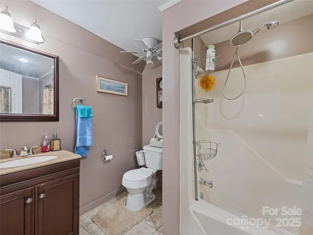 a bathroom with a shower sink vanity mirror and toilet
