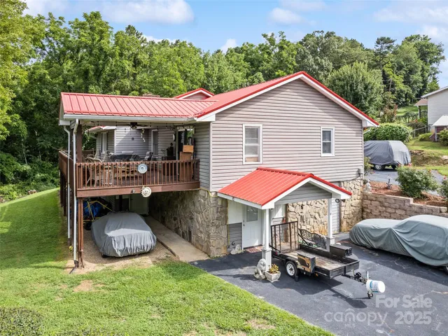 a view of backyard of house with seating area and car parked