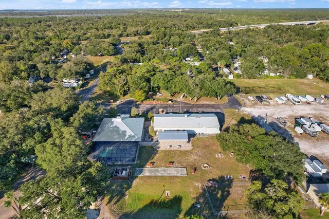 an aerial view of residential houses with outdoor space and trees