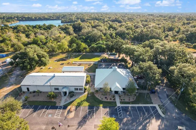 an aerial view of a house with a garden and lake view