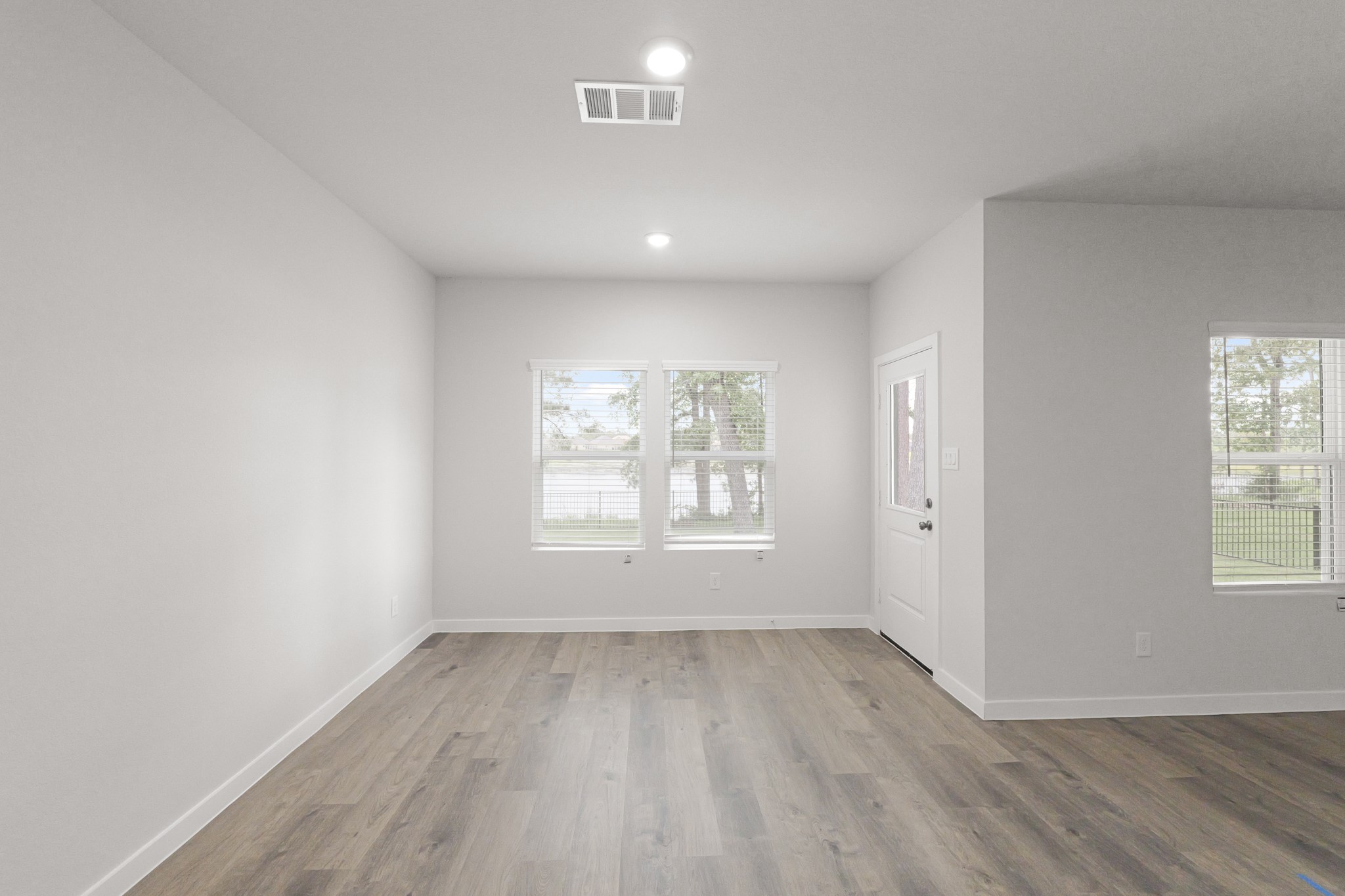 469 Shoreview Drive Conroe, TX 77303 - Photo 19 of 41 an empty room with wooden floor and windows