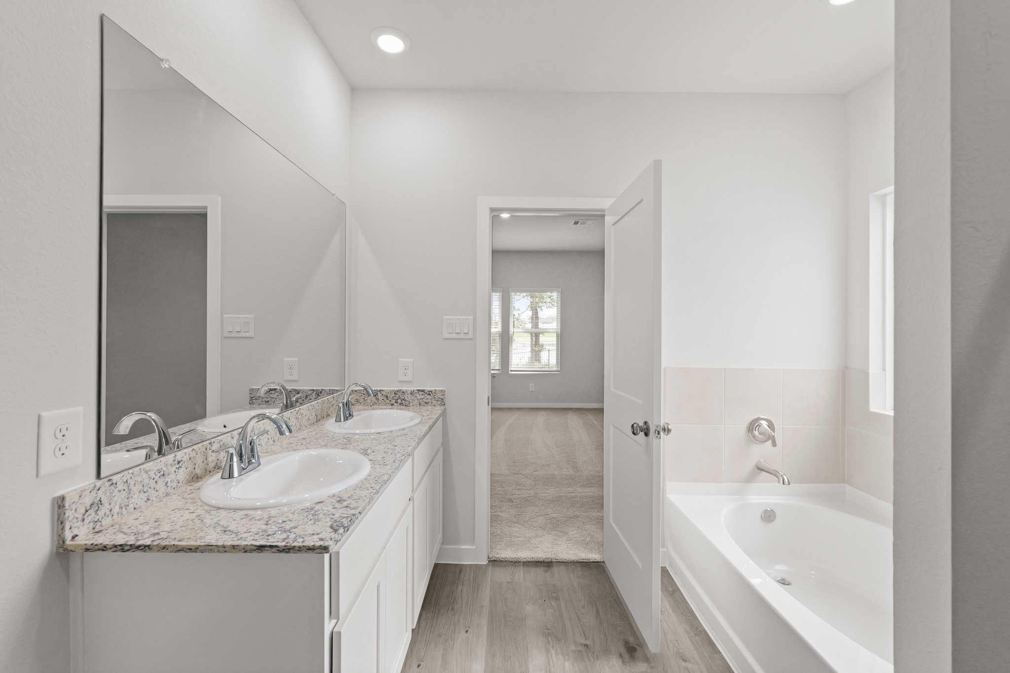 469 Shoreview Drive Conroe, TX 77303 - Photo 28 of 41 a bathroom with a granite countertop sink a bathtub a mirror and vanity