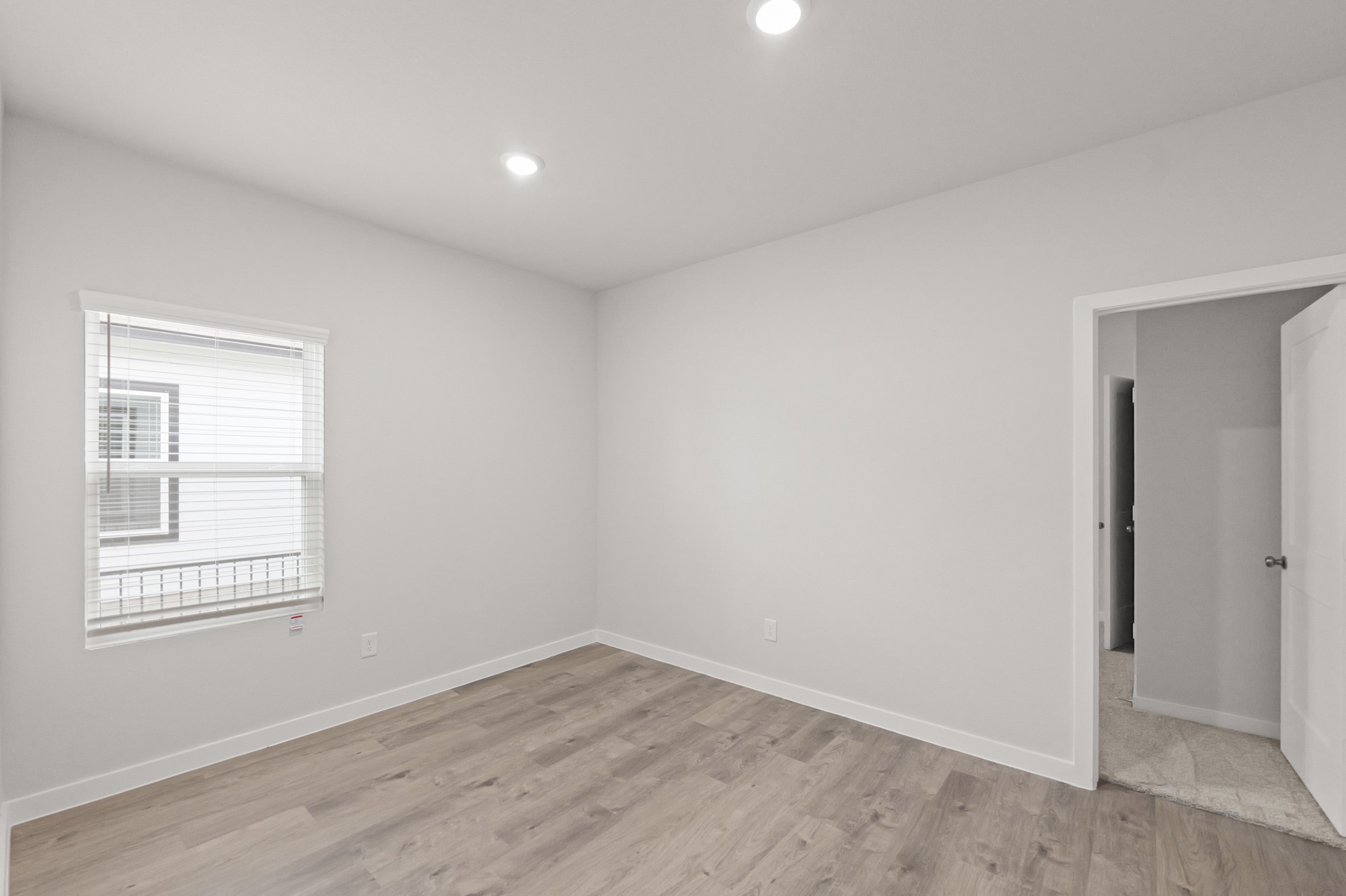 469 Shoreview Drive Conroe, TX 77303 - Photo 8 of 41 an empty room with wooden floor and windows
