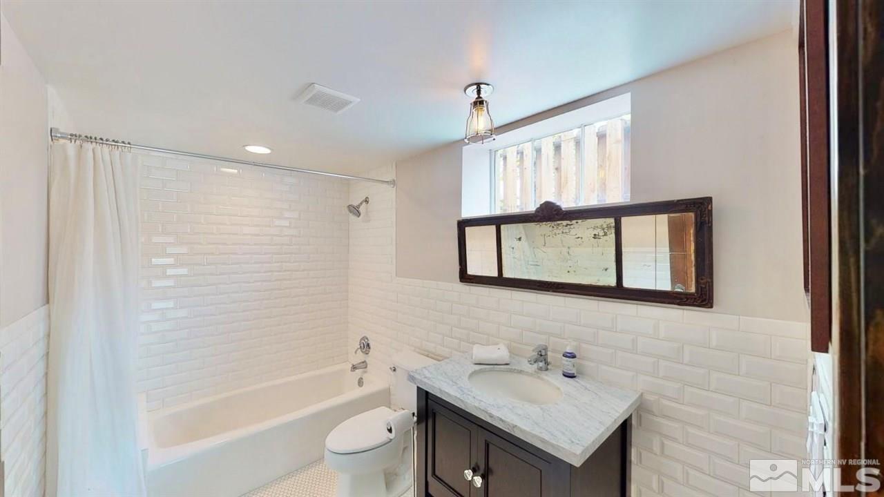 1300 Clough Road Reno, NV 89509 - Photo 30 of 40 a bathroom with a bathtub a sink a mirror and a shower