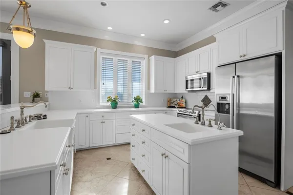 a kitchen with white cabinets and appliances
