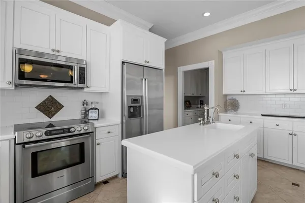 a kitchen with cabinets stainless steel appliances and wooden floor