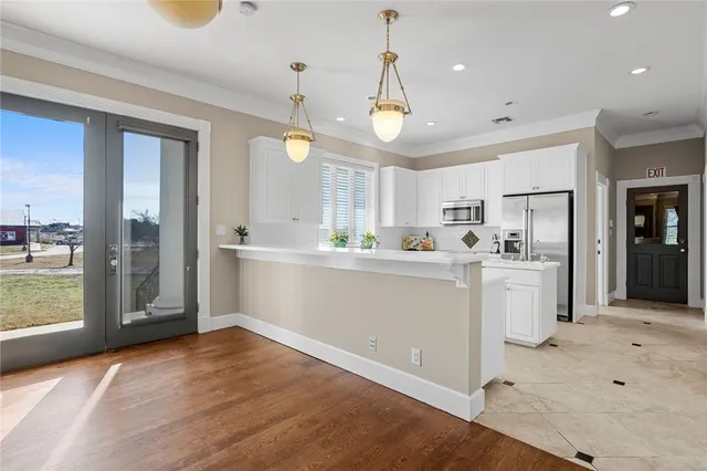a kitchen with white cabinets and refrigerator