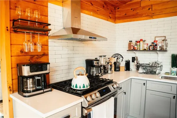 a open kitchen with stainless steel appliances kitchen island granite countertop a sink dishwasher stove and cabinets with wooden floor