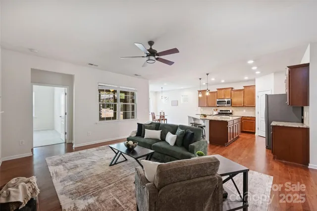 a living room with furniture kitchen and a wooden floor