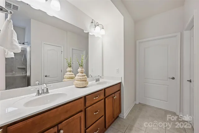 a bathroom with double vanity sinks and a mirror