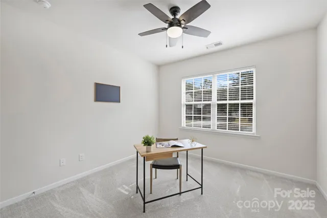 a workspace room with furniture and window