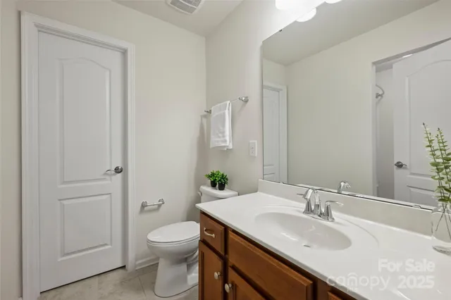 a bathroom with a granite countertop sink toilet and a mirror