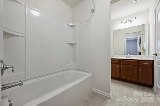 a spacious bathroom with a tub sink and mirror