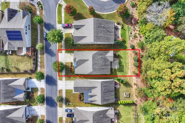 an aerial view of a house with swimming pool and wooden fence