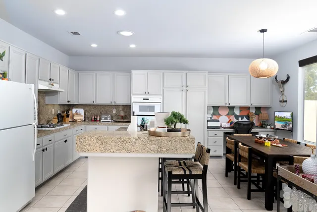 a kitchen with stainless steel appliances granite countertop a sink dishwasher stove and white cabinets