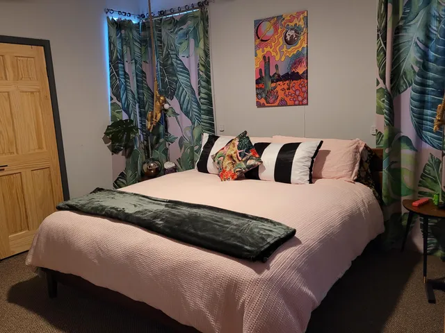 a bedroom with a bed and a painting on the wall