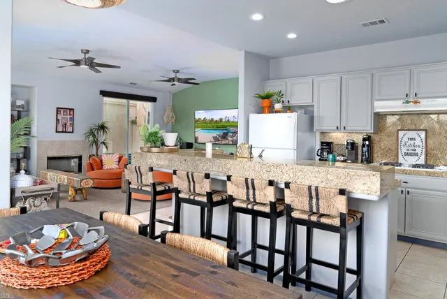a living room with stainless steel appliances furniture and a view of kitchen