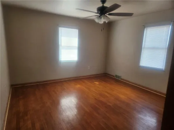 an empty room with a window and a ceiling fan