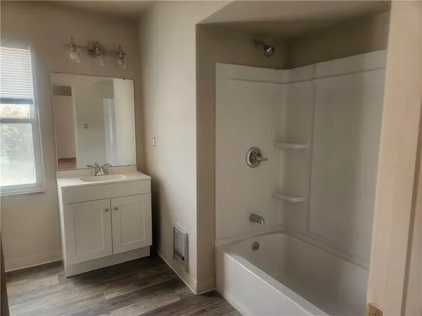 a bathroom with a bathtub a sink a mirror and a shower