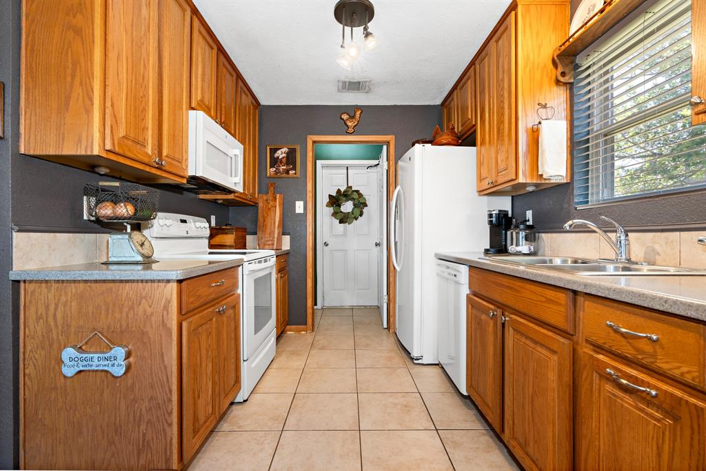 930 Vail Highlands Circle Hewitt, TX 76643 - Photo 11 of 33 a kitchen with stainless steel appliances granite countertop a refrigerator a sink dishwasher and wooden cabinets with wooden floor