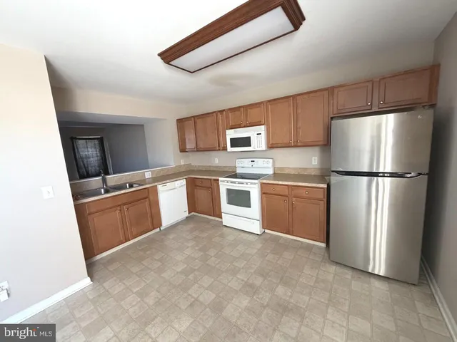 a kitchen with stainless steel appliances a refrigerator sink and microwave
