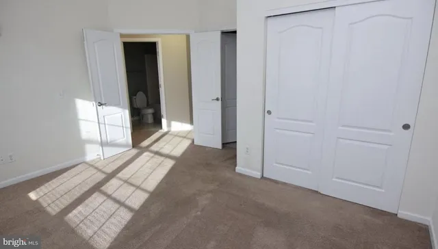 an empty room with closet and mirror