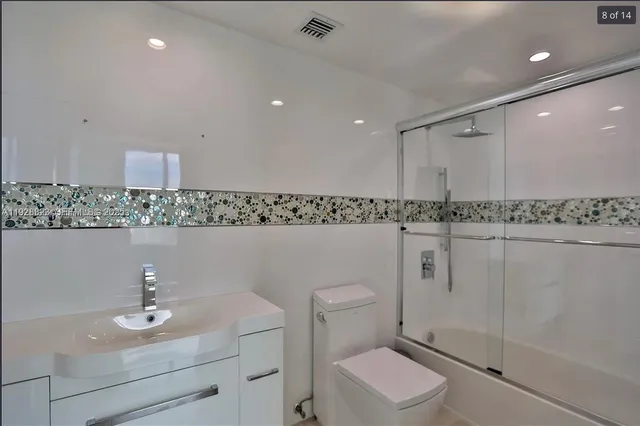 a bathroom with a sink a toilet and mirror