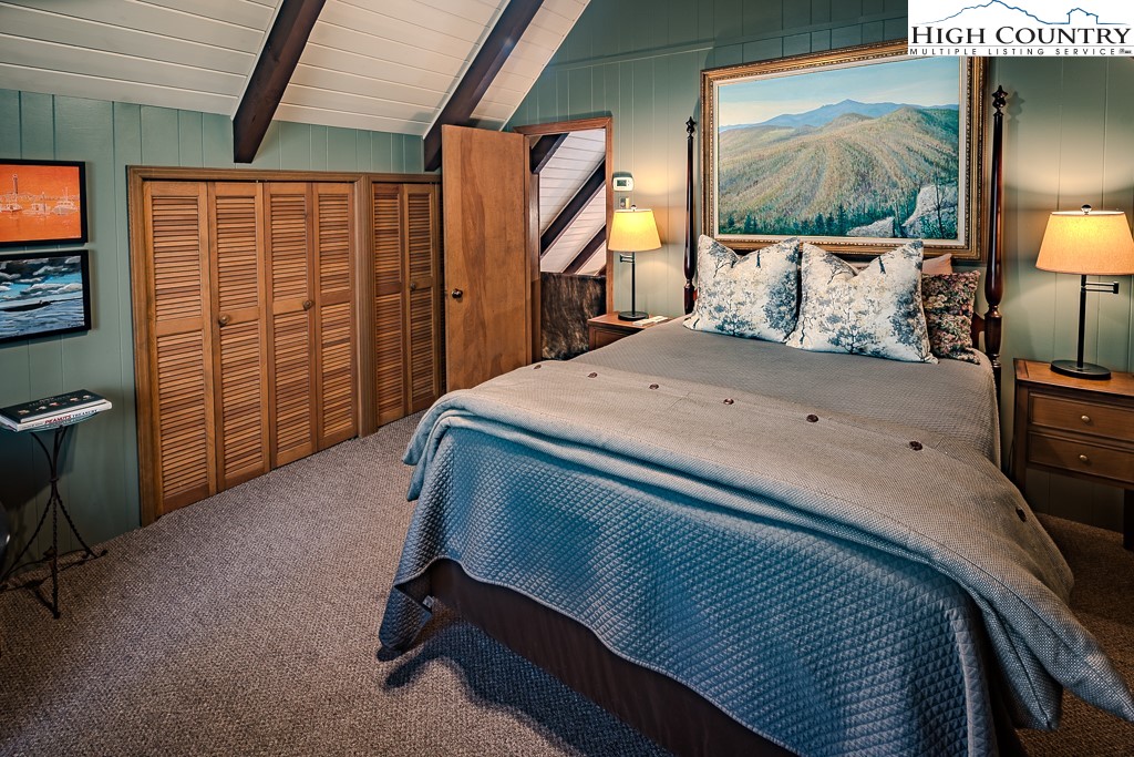 335 Cherry Drive Boone, NC 28607 - Photo 19 of 32 a bedroom with a bed a lamp and large window