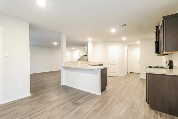 a view of kitchen with granite countertop cabinets and wooden floor
