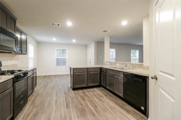 a large kitchen with a sink and stainless steel appliances