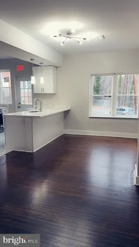 a view of kitchen and hall with wooden floor