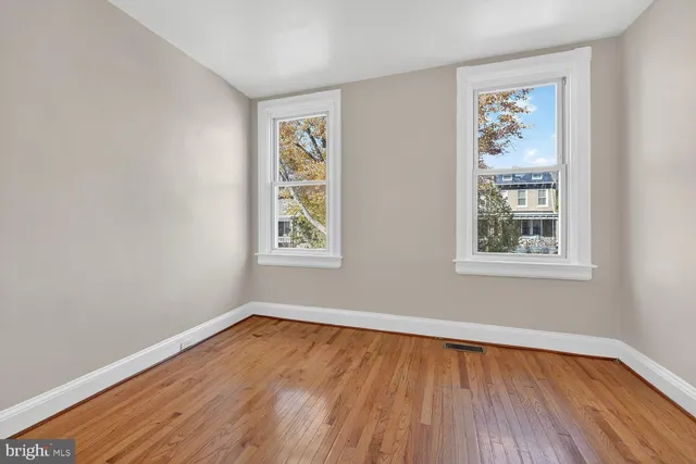 wooden floor in an empty room with a window