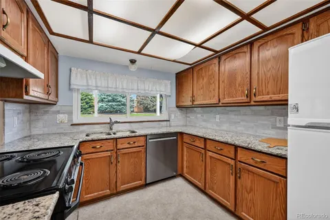 a kitchen with stainless steel appliances granite countertop wooden cabinets stove top oven and sink