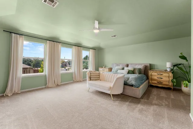 a bedroom with a bed couch and a flat tv screen