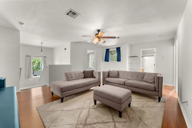 a living room with furniture and wooden floor