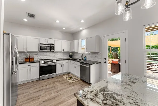 a kitchen with a sink stainless steel appliances and cabinets